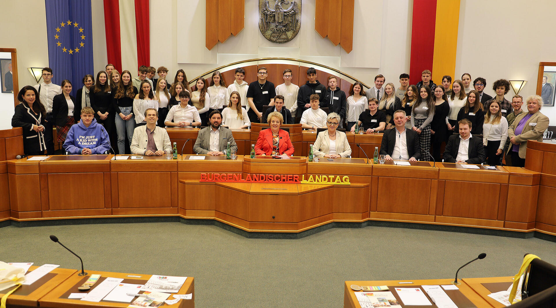 Landtagspräsidentin Verena Dunst (Mitte, vorne) mit Klubobmann Alexander Petschnig (2.v.r., vorne) und den Landtagsabgeordneten Wolfgang Spitzmüller (2.v.l., vorne), Hans Unger (3.v.l., vorne), Doris Prohaska (3.v.r., vorne), Barbara Glück (stehend, l.) sowie Auslandsdiener Jonathan Dorner (r., vorne) mit den Professoren sowie den Schülerinnen und Schülern im Landtagssitzungssaal.