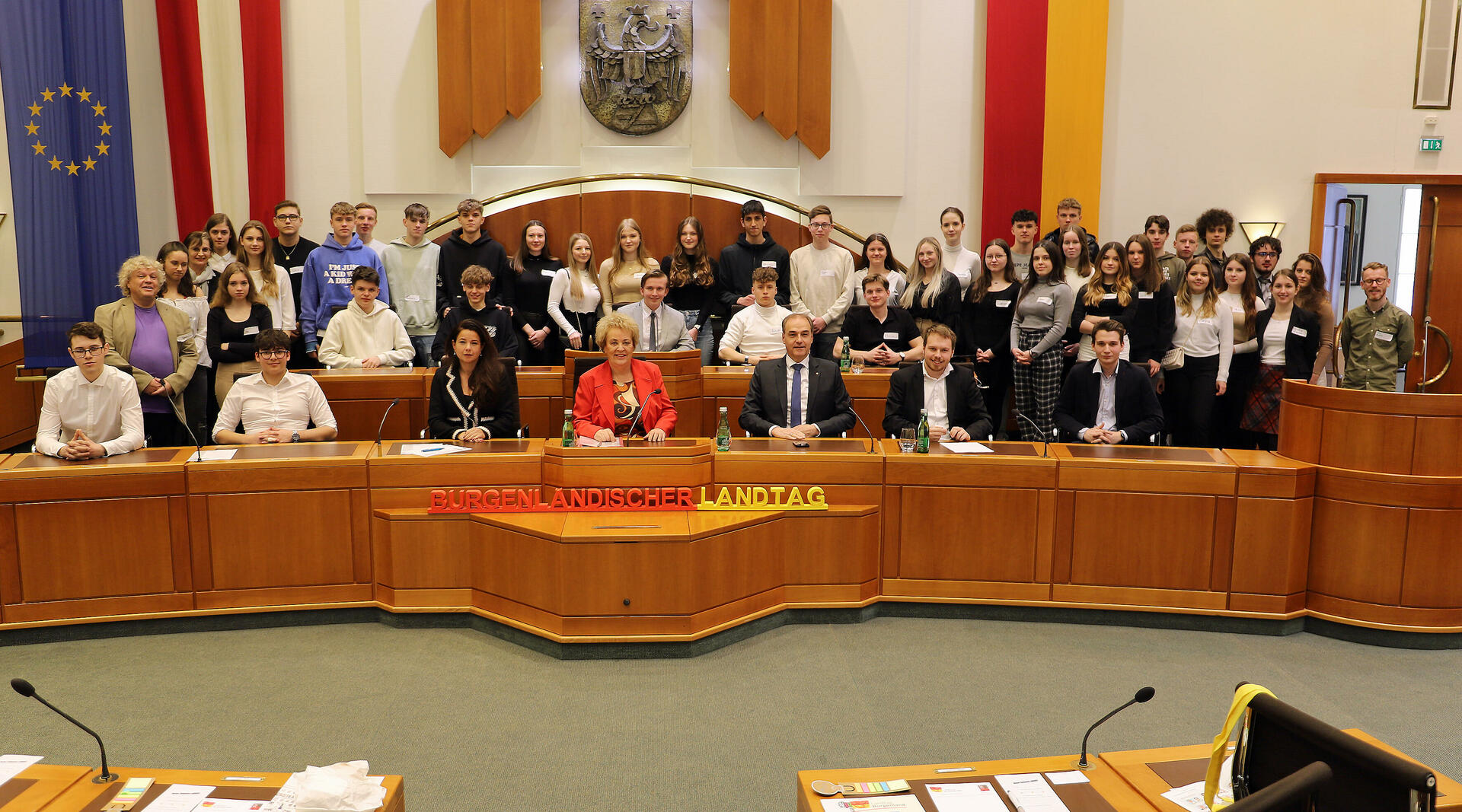 Landtagspräsidentin Verena Dunst (Mitte, vorne) mit Landesrat Leonhard Schneemann (3.v.r., vorne), Barbara Glück (3.v.l., vorne) sowie Jonathan Dorner (2. v. r., vorne) mit den Professoren sowie den Schülerinnen und Schülern im Landtagssitzungssaal.